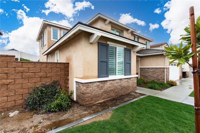 view of side of property with stone siding, stucco siding, and fence