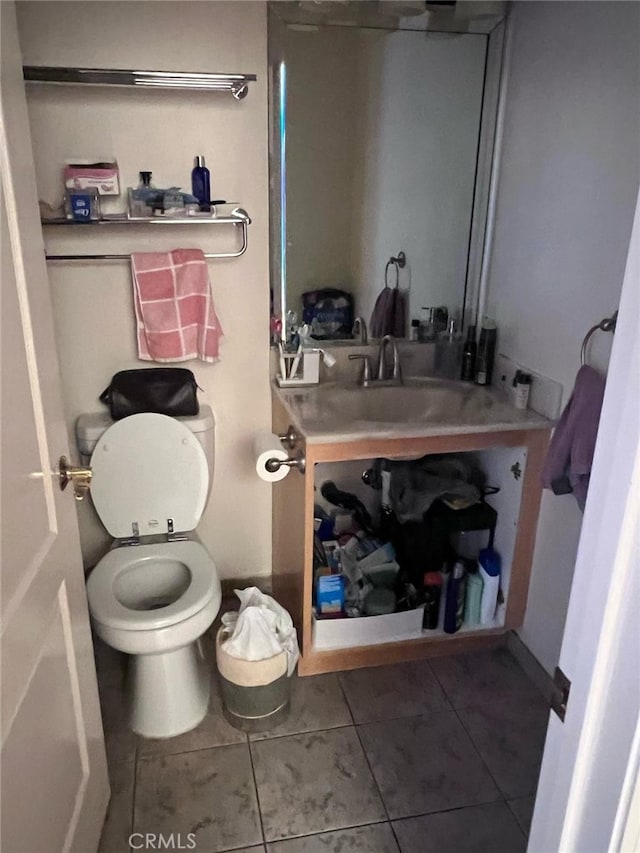 half bath featuring tile patterned flooring, vanity, and toilet