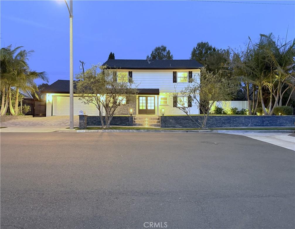 view of front facade with concrete driveway, fence, and french doors