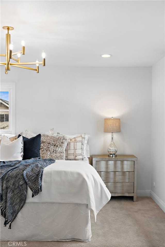 bedroom featuring carpet, baseboards, and an inviting chandelier