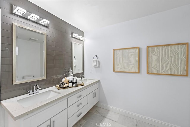 bathroom with a sink, baseboards, double vanity, and marble finish floor