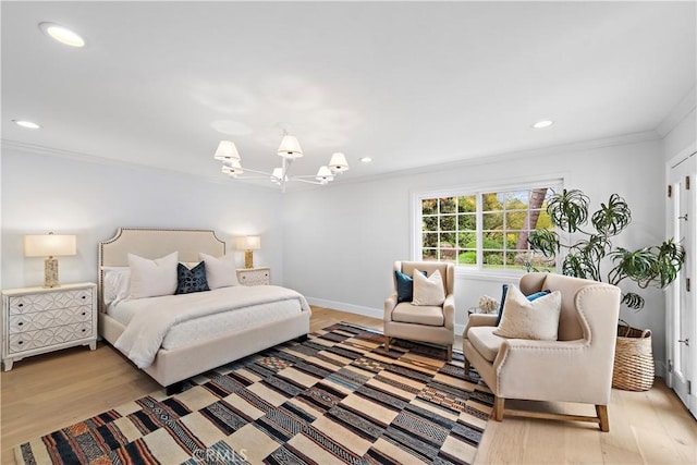 bedroom featuring light wood finished floors, crown molding, an inviting chandelier, and baseboards