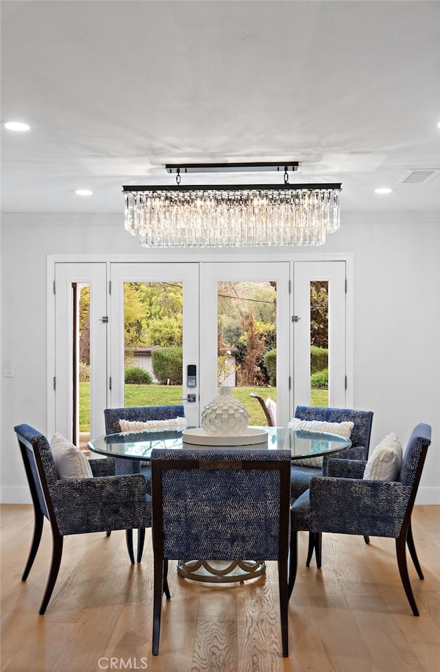 dining area with baseboards, an inviting chandelier, crown molding, recessed lighting, and light wood-style flooring