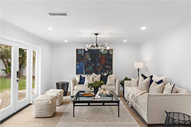 living room with crown molding, visible vents, recessed lighting, wood finished floors, and a notable chandelier