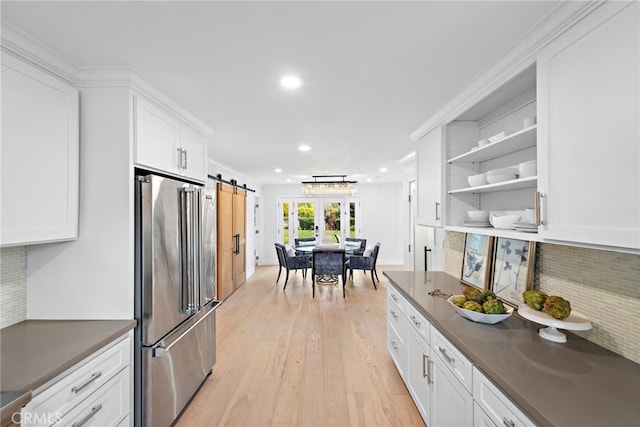 kitchen featuring light wood-style floors, high end refrigerator, dark countertops, and recessed lighting