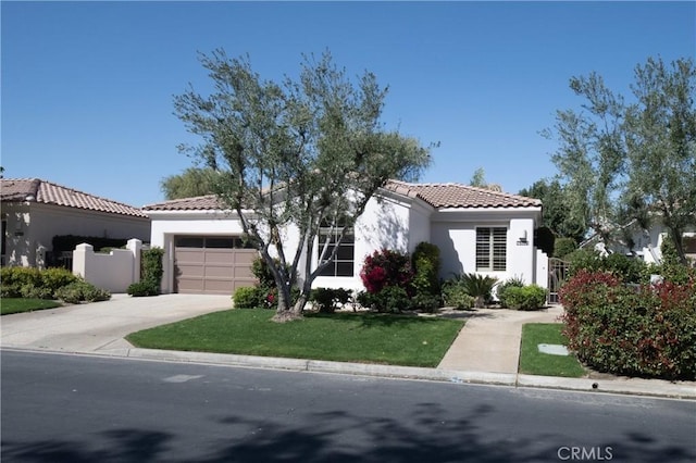 mediterranean / spanish home featuring a garage, fence, concrete driveway, a tiled roof, and stucco siding