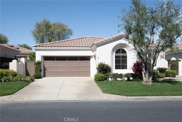 mediterranean / spanish-style home with a garage, concrete driveway, fence, and stucco siding