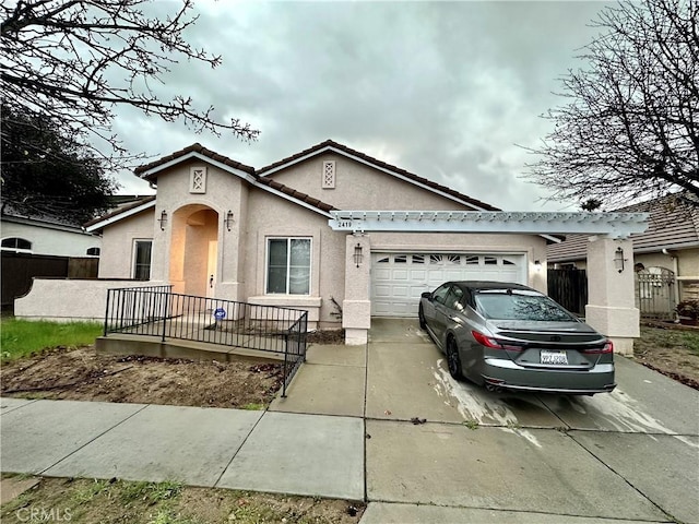 view of front of property with stucco siding, an attached garage, fence, driveway, and a tiled roof