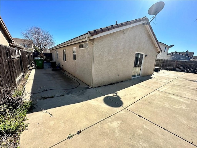 back of house with a patio area, a fenced backyard, a tiled roof, and stucco siding