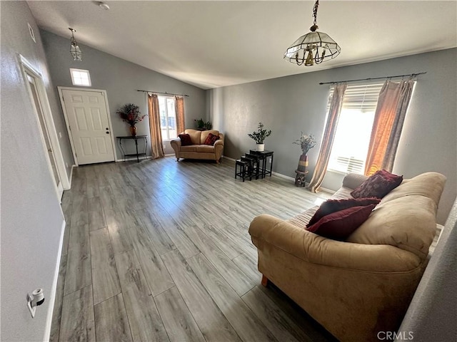 living room with baseboards, vaulted ceiling, and wood finished floors