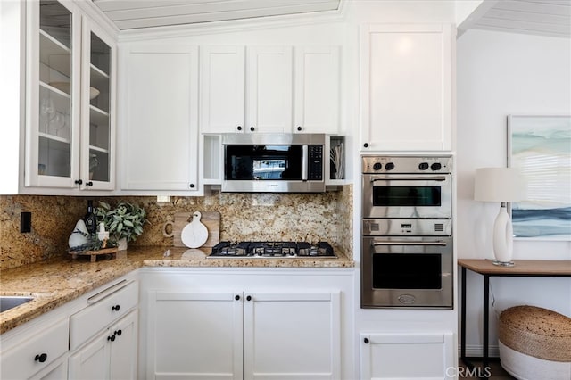 kitchen featuring glass insert cabinets, backsplash, appliances with stainless steel finishes, and white cabinets