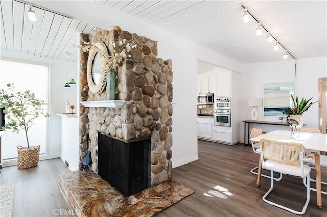 living area featuring dark wood-style floors, a fireplace, and vaulted ceiling