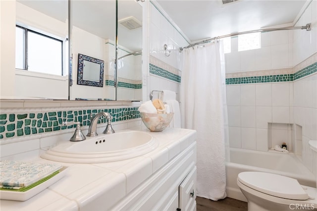 full bath featuring visible vents, toilet, tasteful backsplash, shower / tub combo, and vanity