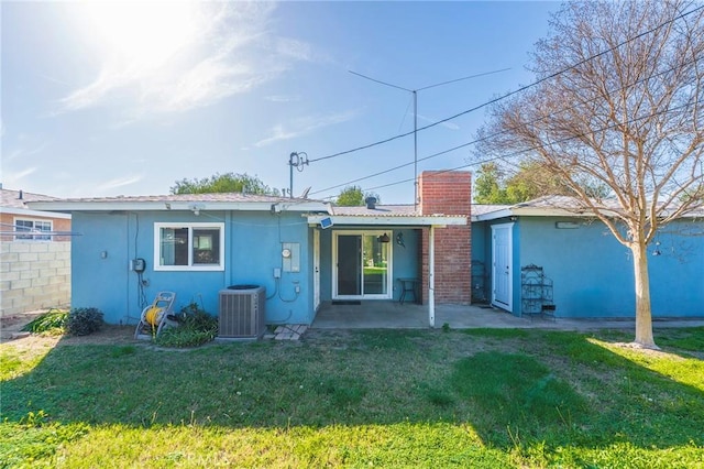 rear view of house with a patio, central air condition unit, fence, a lawn, and stucco siding