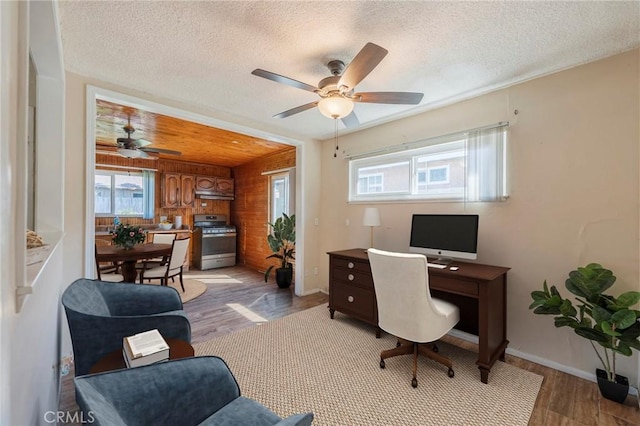 office space with light wood finished floors, ceiling fan, and a textured ceiling