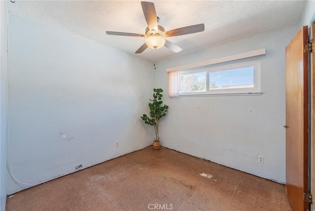 empty room featuring a ceiling fan, a textured ceiling, and tile patterned floors