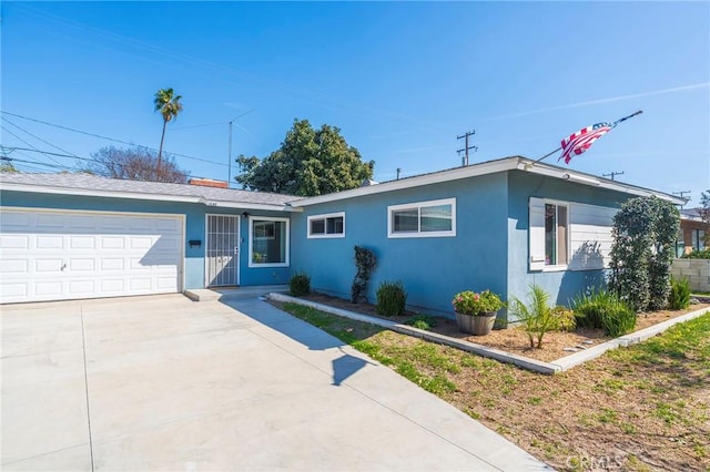 single story home featuring a garage, driveway, and stucco siding