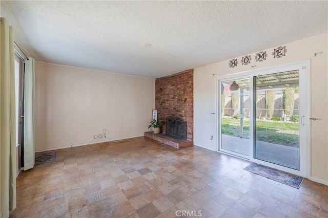 unfurnished living room with a fireplace, a textured ceiling, and tile patterned floors