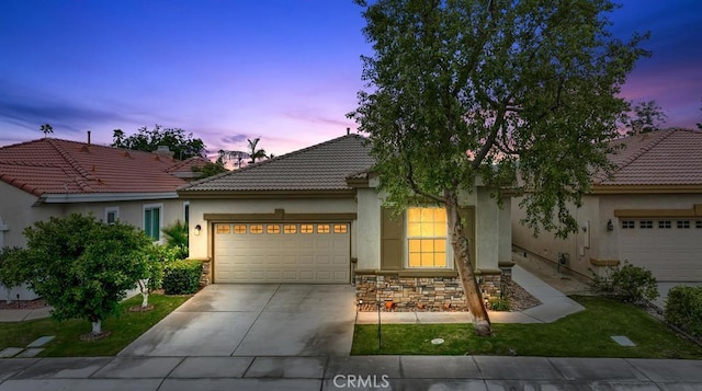 82745 Odlum Dr, Indio, CA 92201 - view of front of home with an attached garage, stucco siding, a tile roof, and concrete driveway