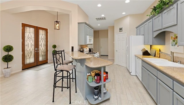 82745 Odlum Dr, Indio, CA 92201 - kitchen featuring white appliances, gray cabinets, french doors, arched walkways, and recessed lighting
