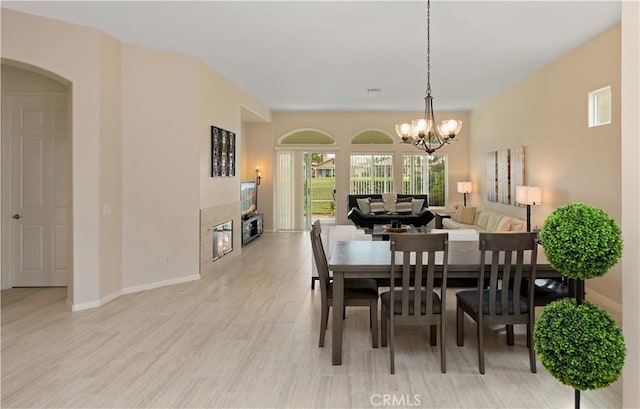 82745 Odlum Dr, Indio, CA 92201 - dining area featuring a chandelier, a tiled fireplace, and light wood-style flooring