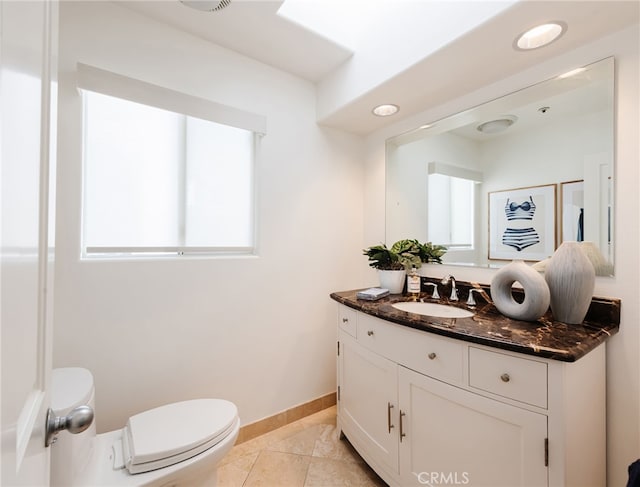 half bathroom featuring tile patterned flooring, baseboards, toilet, recessed lighting, and vanity