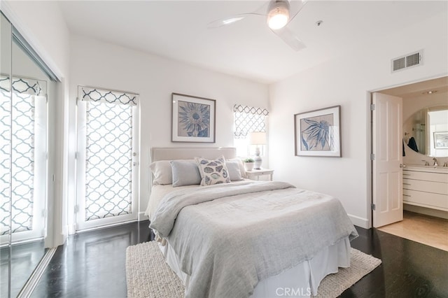 bedroom featuring visible vents, multiple windows, a ceiling fan, and wood finished floors