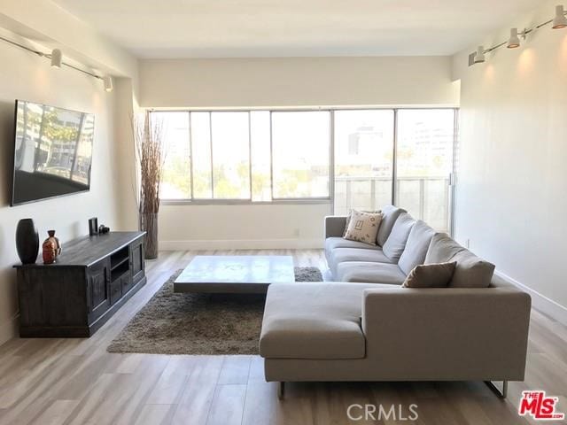 living area with baseboards and wood finished floors