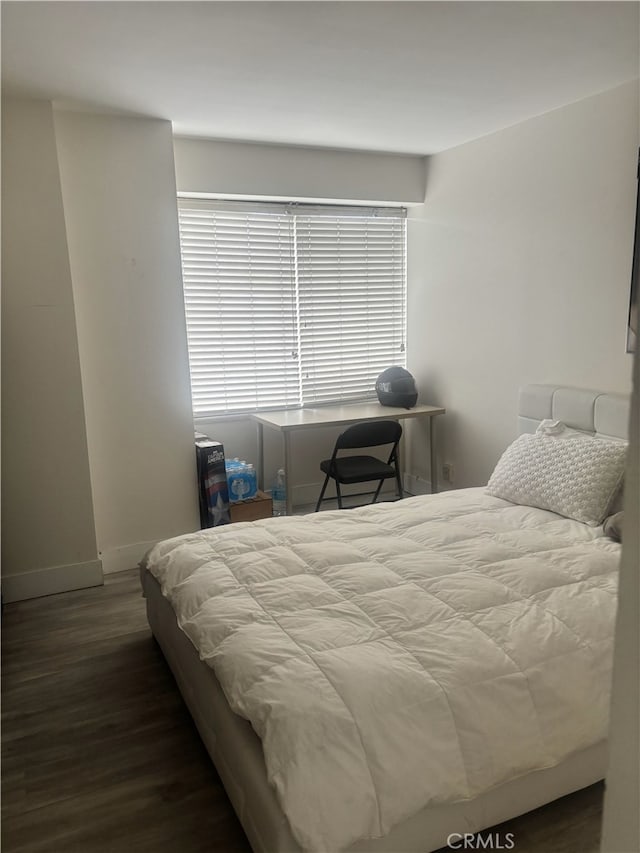 bedroom with wood finished floors and baseboards