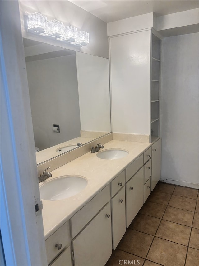 full bath with double vanity, a sink, and tile patterned floors