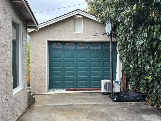 garage featuring ac unit and concrete driveway