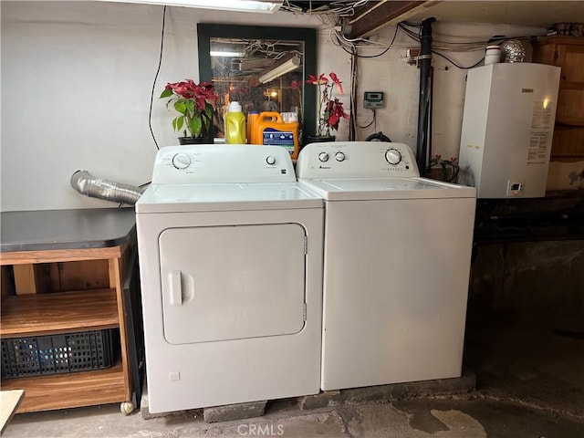 clothes washing area with washer and dryer, tankless water heater, and laundry area