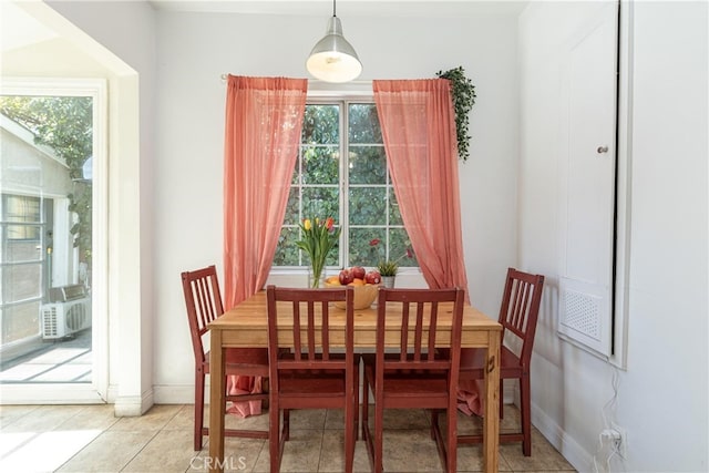 dining space featuring light tile patterned floors, baseboards, cooling unit, and a healthy amount of sunlight