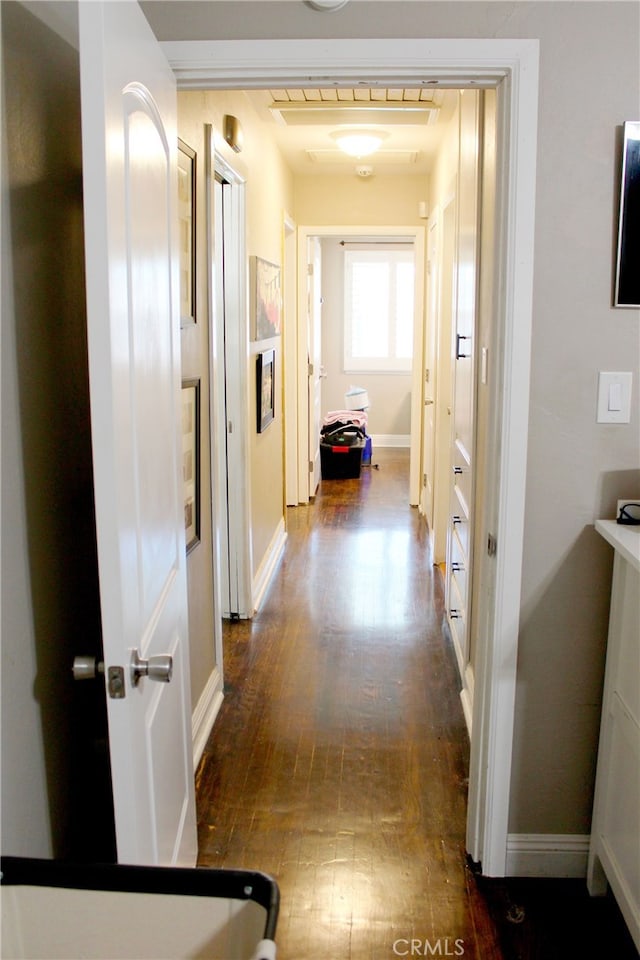 hall with baseboards and dark wood finished floors