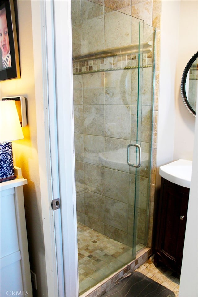 bathroom with a shower stall and vanity