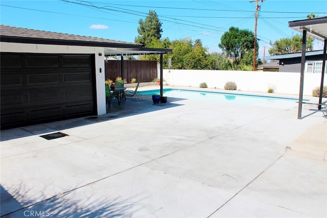 garage featuring fence and a fenced in pool