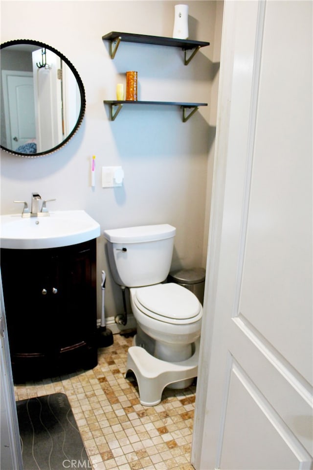 half bathroom with toilet and vanity