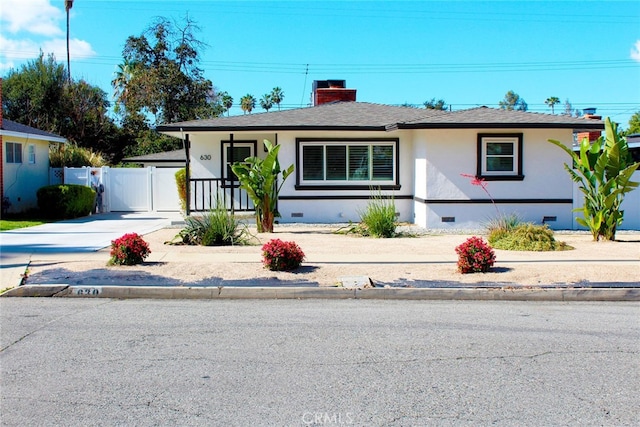 view of front of house featuring stucco siding, a gate, fence, crawl space, and a chimney