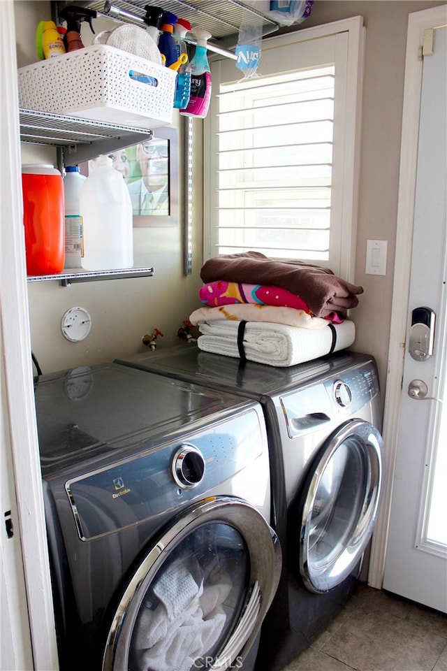 laundry room featuring washing machine and clothes dryer, laundry area, and tile patterned floors