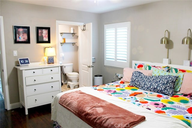 bedroom with ensuite bath and dark wood-style floors