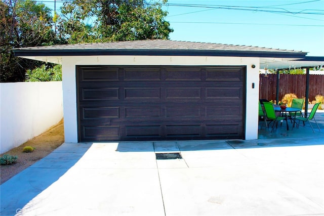 detached garage featuring fence