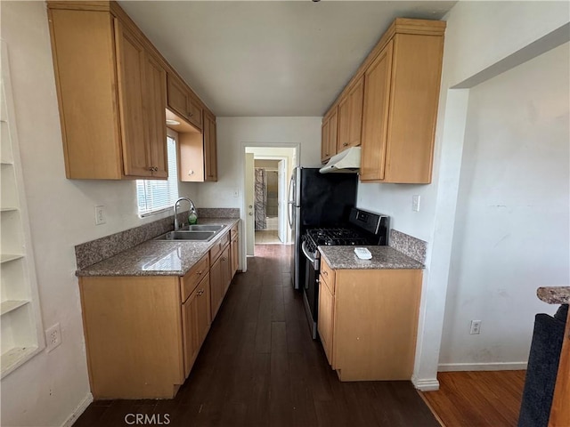 kitchen featuring under cabinet range hood, stainless steel range with gas stovetop, dark wood-style floors, and a sink