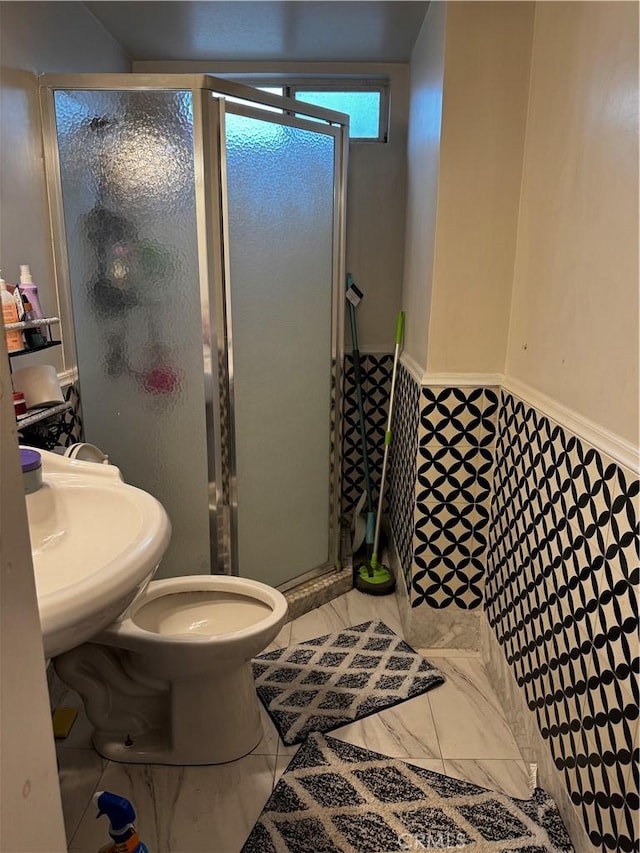 full bathroom with a sink, toilet, marble finish floor, and a stall shower