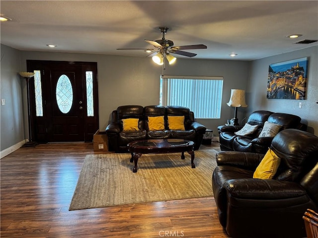 living area featuring a wealth of natural light, visible vents, baseboards, and wood finished floors