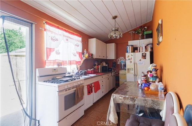 kitchen with tile patterned floors, white cabinets, white appliances, and vaulted ceiling