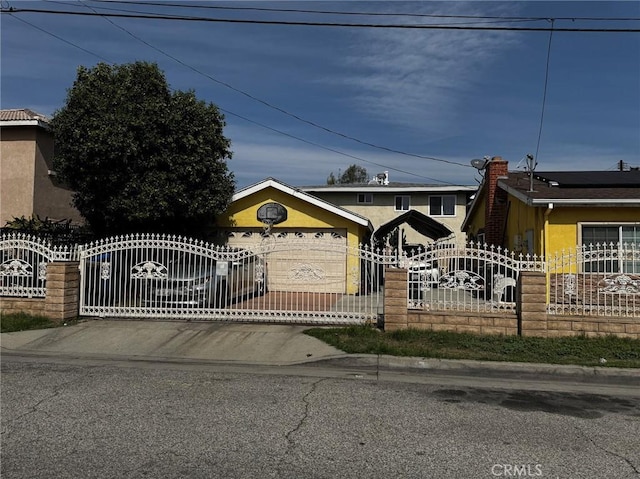 view of front of property with a gate, a fenced front yard, and stucco siding