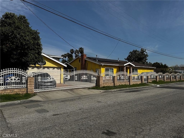 view of front of house with a fenced front yard, roof mounted solar panels, and a gate