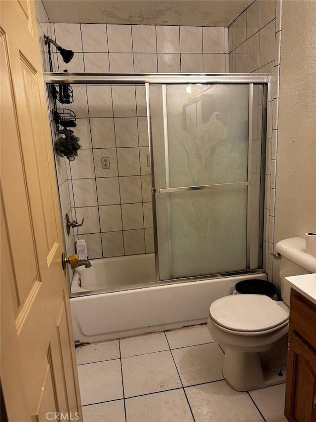 bathroom with tile patterned flooring, toilet, vanity, and combined bath / shower with glass door