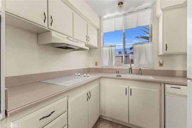 kitchen featuring white appliances, light countertops, under cabinet range hood, and a sink