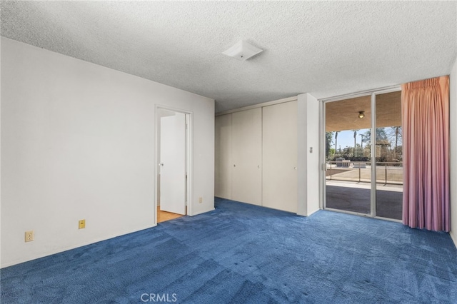 spare room with a textured ceiling and carpet flooring